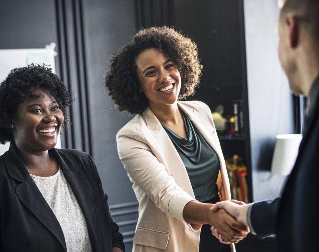 job candidate enjoying candidate experience and shaking hands with hiring manager
