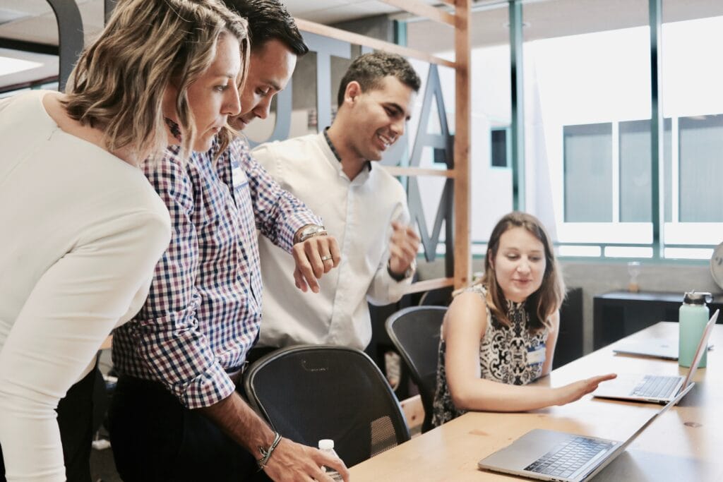 Employee sitting in front of a laptop making a presentation to colleagues