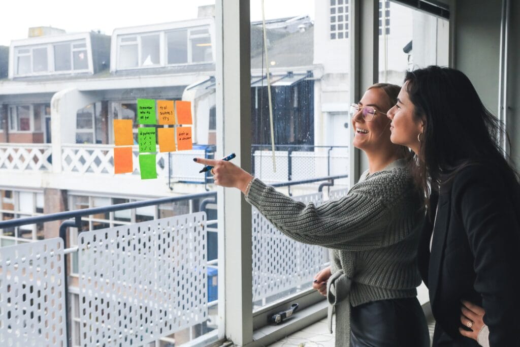 Two HR professionals creating a recruitment operations strategy on a whiteboard