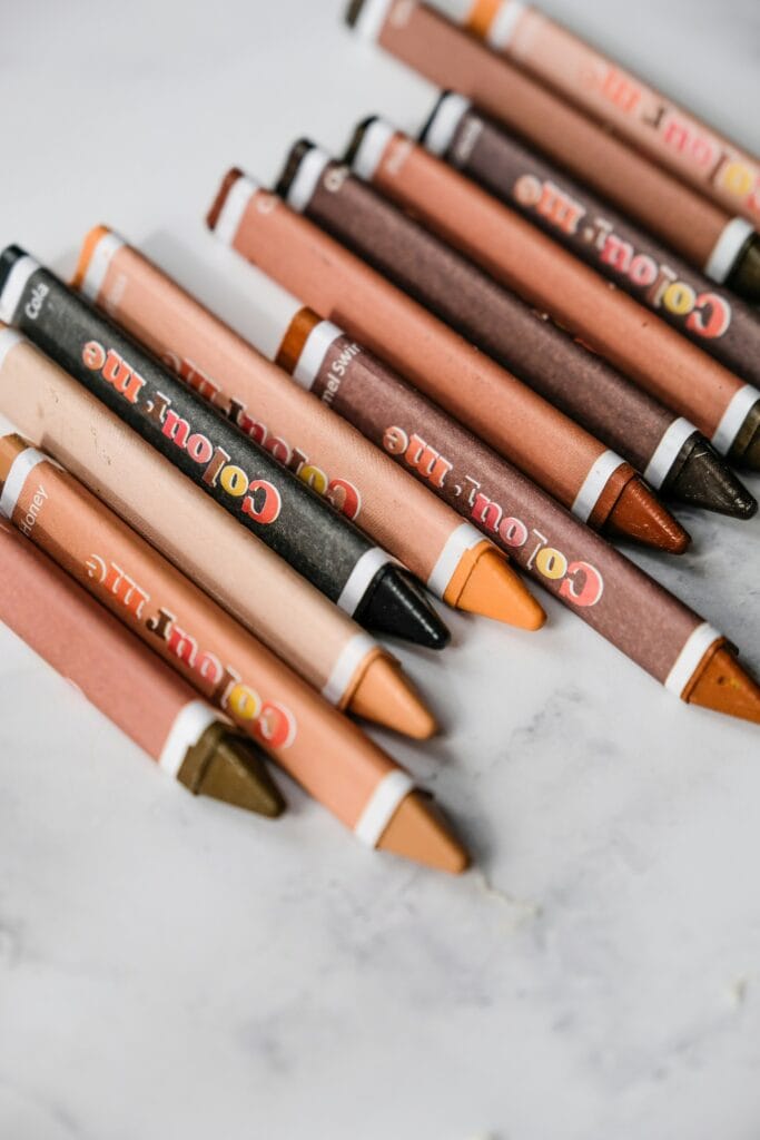 A variety of skin tone crayons laid out on a counter.