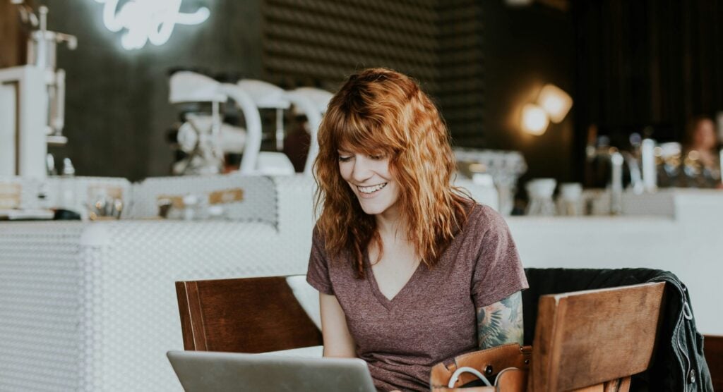 Woman on laptop recording a one-way interview for a job application.