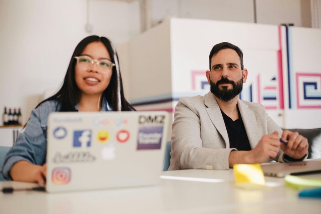 Two HR employees at a laptop reviewing talent intelligence platforms