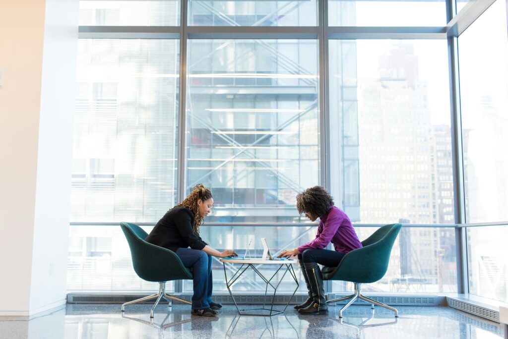 Employees on laptops in front of a window using their top hard skills.