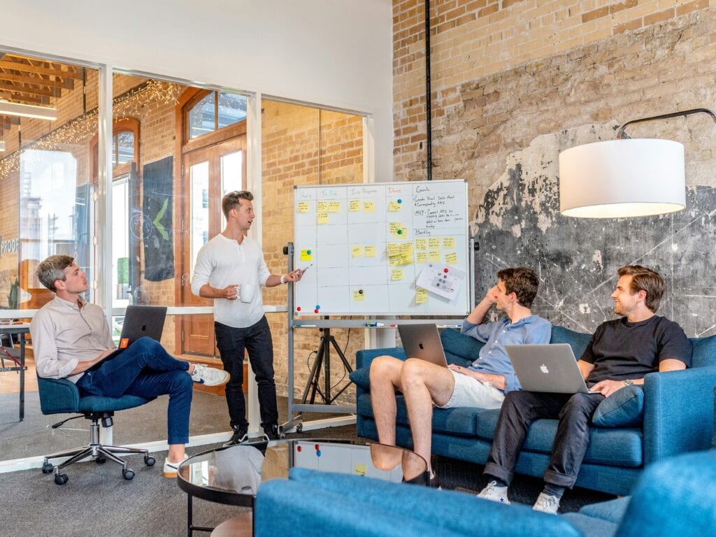 Employees around a whiteboard discussing career development goals.