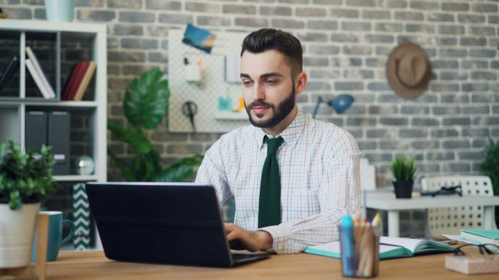 Professional sitting at a laptop learning about what the head of human resources does.