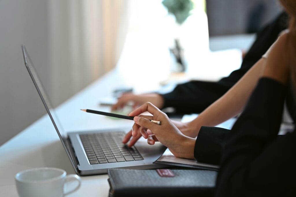 Person using a pencil to point at a laptop screen discussing the ethics of AI.