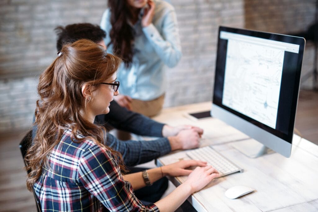 Two people sitting at a computer working on AI training for employees.
