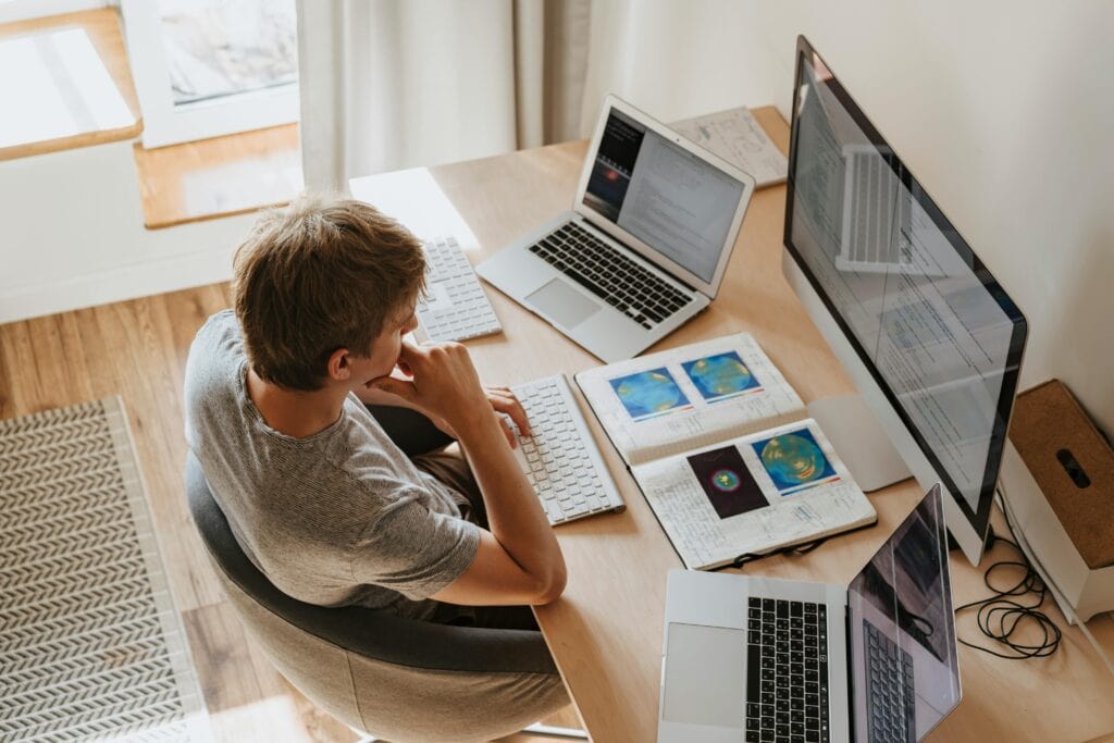 Man seated at desk in front of computer using AI for learning and development.