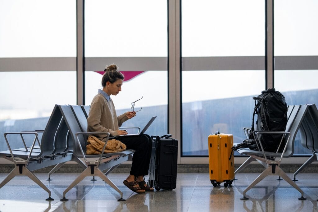 A digital nomad sitting on their laptop while at the airport.
