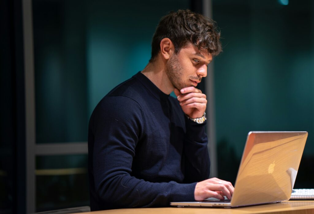 Man standing at laptop learning about white fonting.