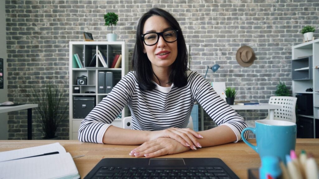 Woman sitting at laptop using video interviewing.