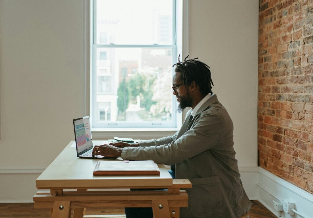 HR manager sitting at laptop reviewing on-demand hiring assessments.