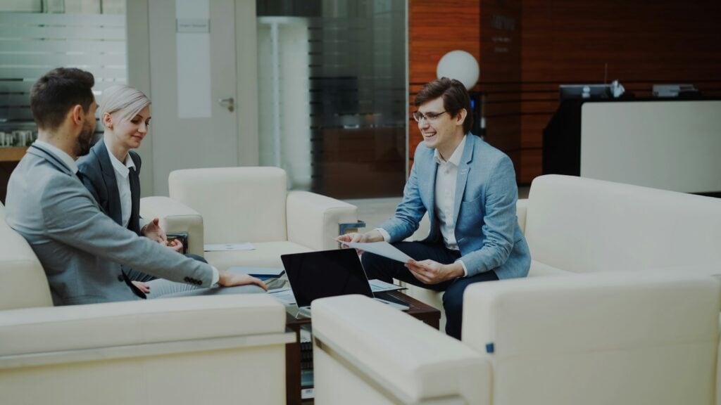 Coworkers sitting in office discussing AI red flags in resume screening.
