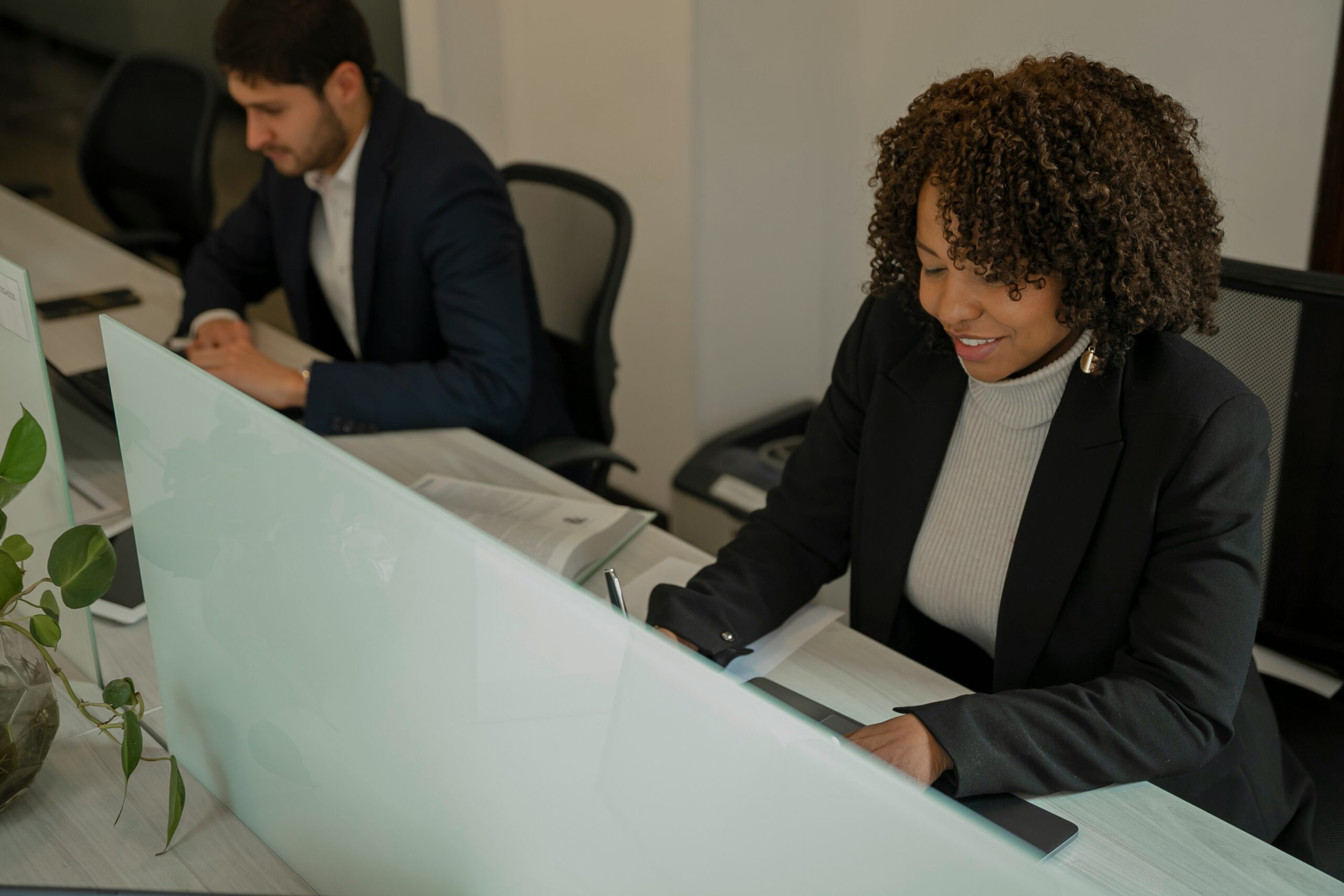 Two employees sitting at computers side by side.